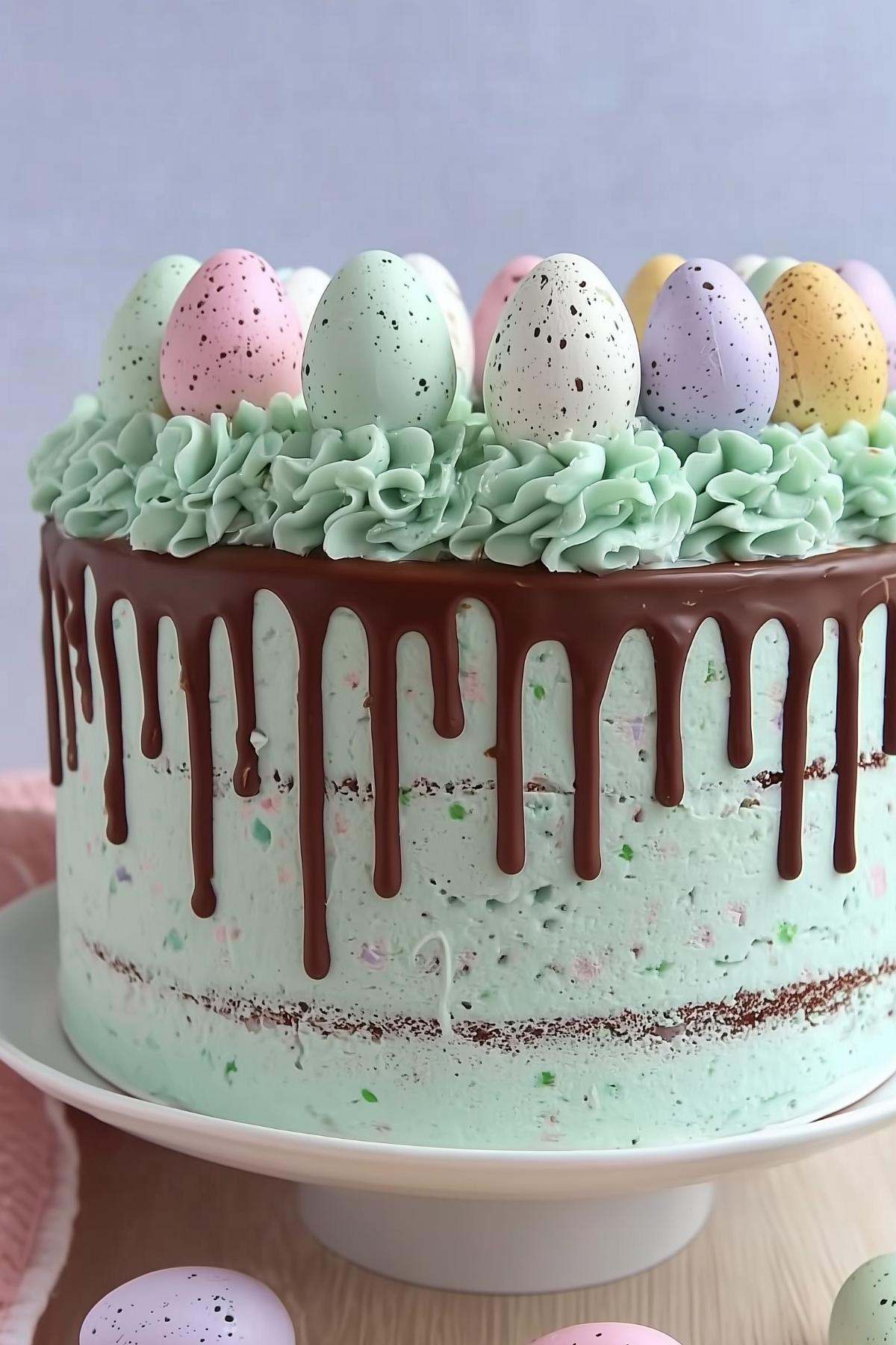 : Easter Speckled Egg Drip Cake with colorful mini eggs and chocolate ganache