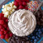 Creamy chocolate protein fluff in a bowl topped with berries