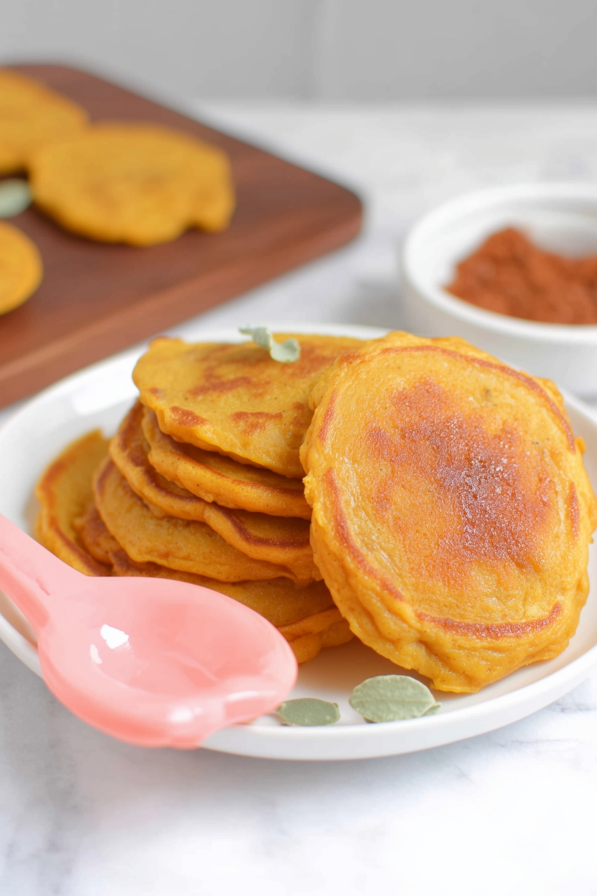 Pumpkin pancakes with maple syrup and berries on a plate