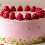 Raspberry Pistachio Cake layered with raspberry filling and pistachio frosting